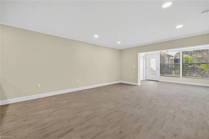 Living room featuring wood tiled floors, recessed lighting, and crown molding