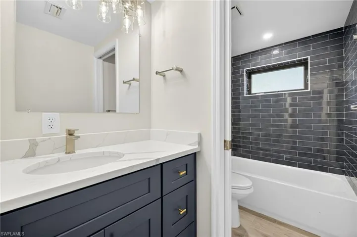 Full bathroom featuring vanity, shower / bathtub combination, and wood tiled floors