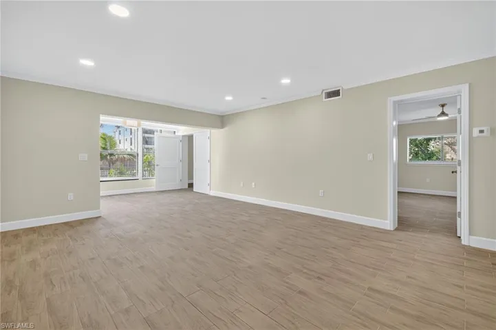 Living room with recessed lighting, light wood-style floors, and ornamental molding