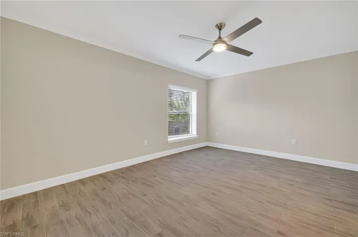 Unfurnished room with ornamental molding, light wood-style floors, and a ceiling fan