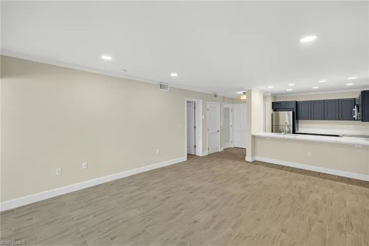 Unfurnished living room featuring recessed lighting, crown molding, and light wood-type flooring