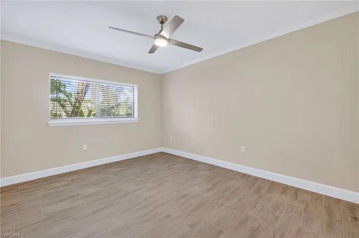 Unfurnished room featuring light wood-style floors and crown molding