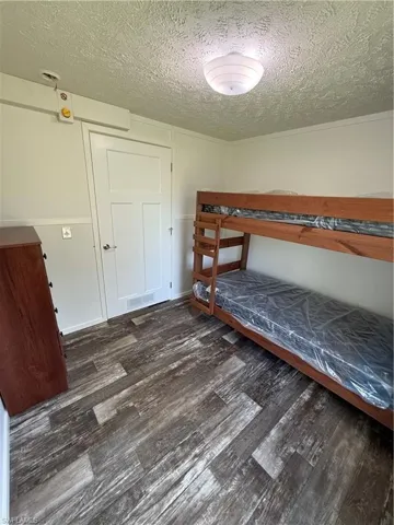 Wood-finish flooring, white paneled door, and recessed lighting