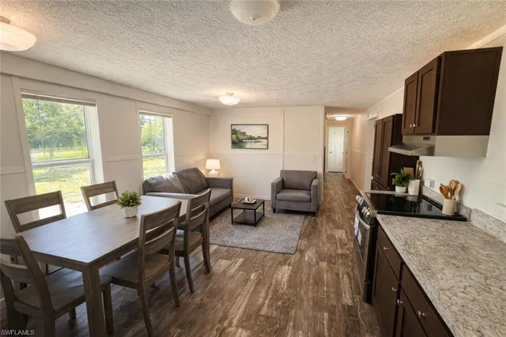Open-concept living space featuring wood-finish flooring, white walls, and built-in cabinetry