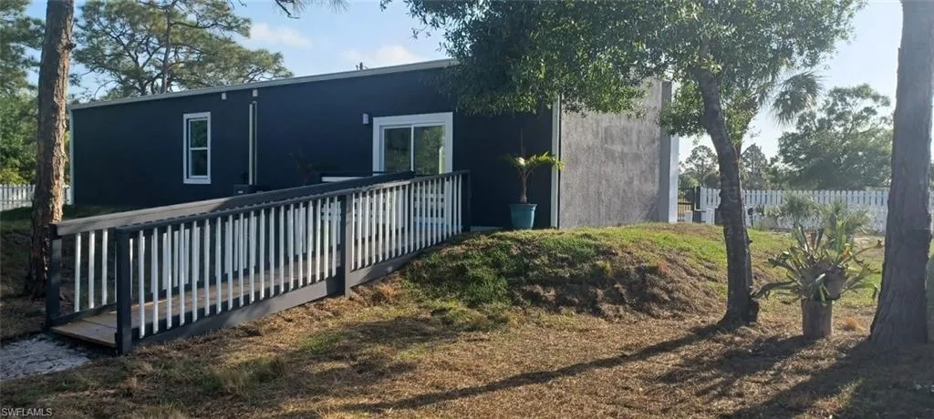 Back of property featuring a deck and fence