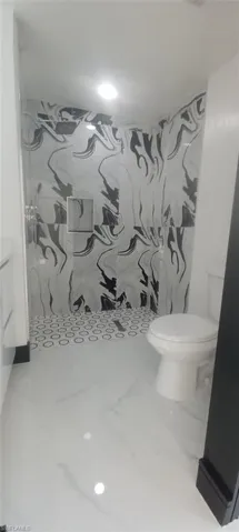Bathroom with walk in shower, vanity, and toilet