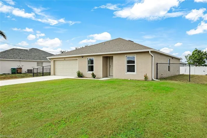 View of front of property with a front lawn, central AC unit, and a garage