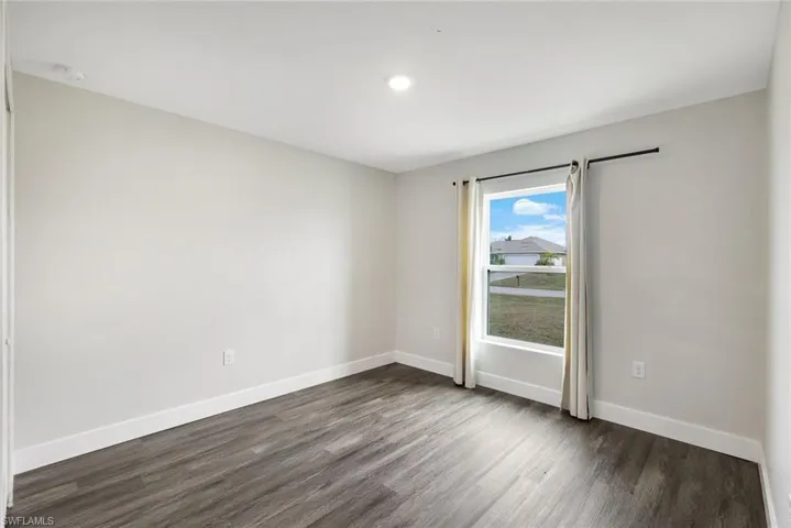 Empty room featuring dark hardwood / wood-style floors