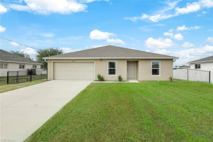 View of front of home featuring a front lawn and a garage