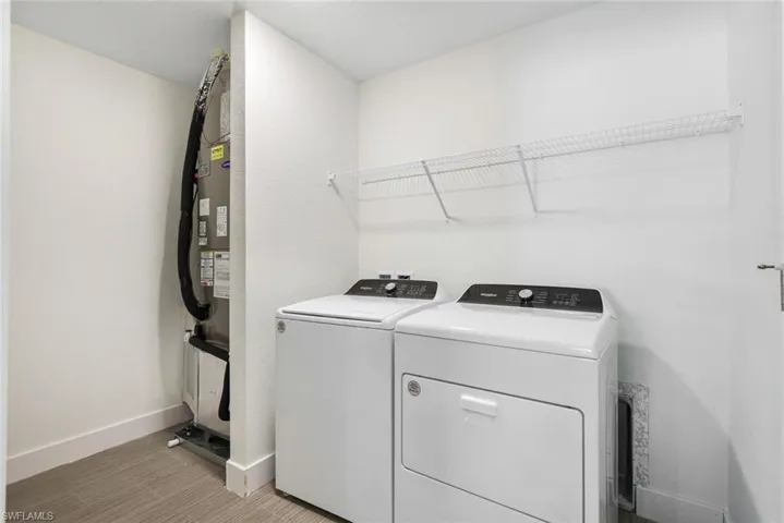 Clothes washing area featuring separate washer and dryer and light hardwood / wood-style flooring