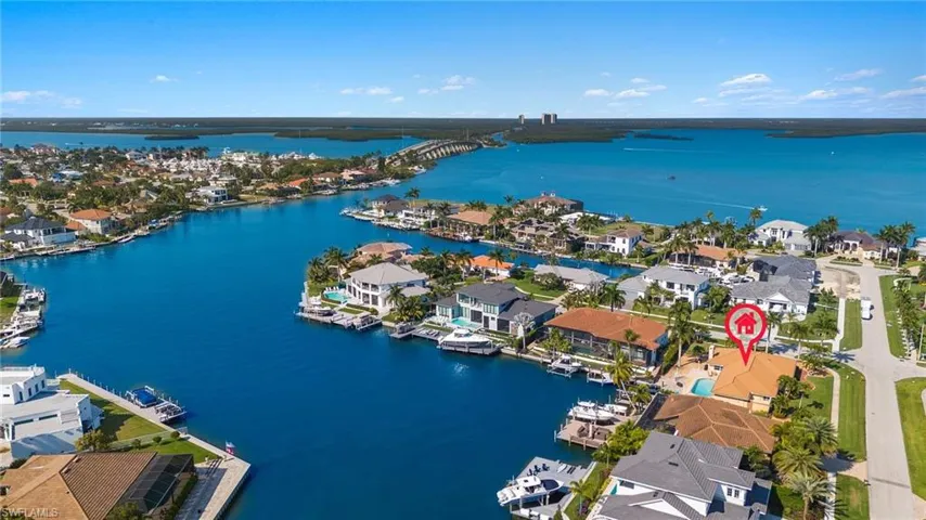 Aerial view of property's location featuring a nearby body of water and nearby suburban area