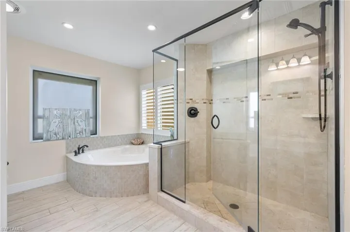 Bathroom featuring a stall shower, a bath, and recessed lighting