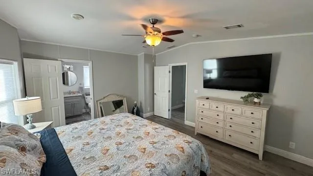 Bedroom with crown molding, connected bathroom, ceiling fan and vaulted ceiling