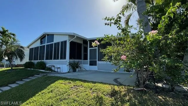 Rear view of house featuring gentle steps to boat slip, nice patio leading into each of the two lanais