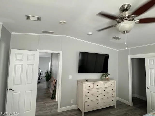 Bedroom with crown molding, hardwood / wood-style floors, and ceiling fan