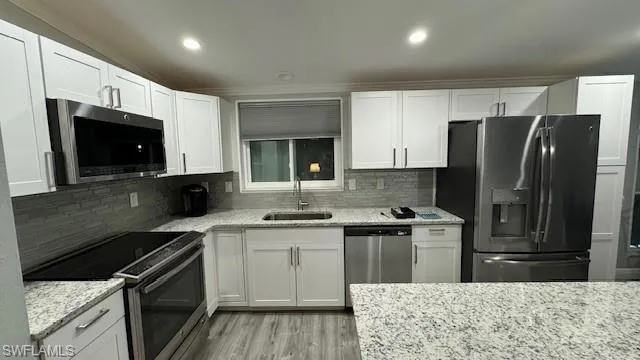 Kitchen featuring decorative backsplash, stainless steel appliances, granite counter tops