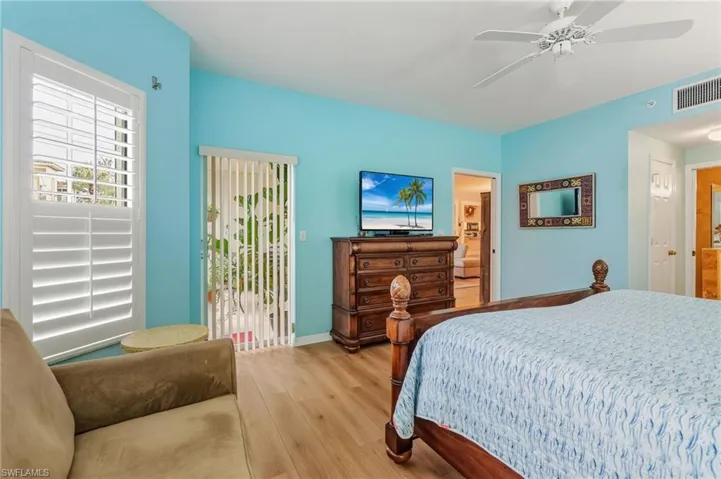 Bedroom with wood finished floors, access to outside, and a ceiling fan