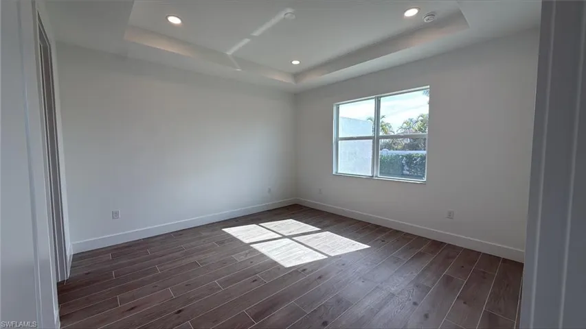 Primary bedroom suite with tray ceiling and private backyard view