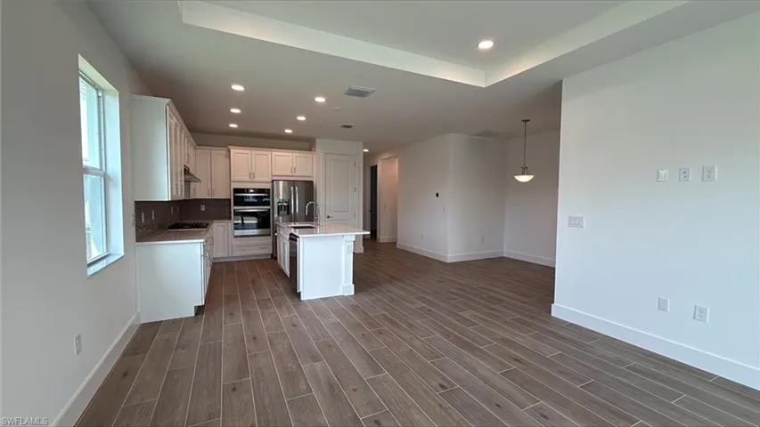 Great room living area with tray ceiling