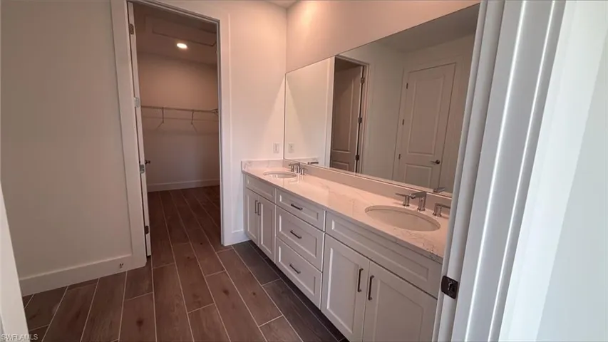 Primary bathroom with dual sinks, quartz countertops and spacious walk-in closet