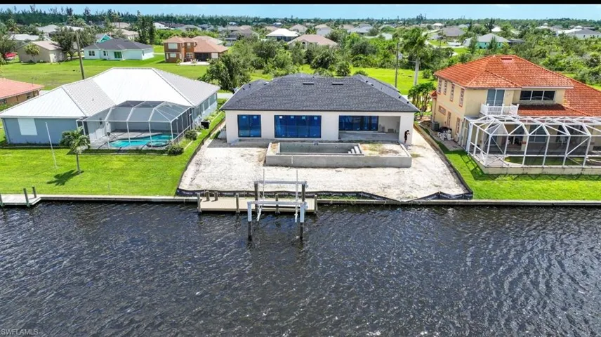 Dock area featuring a sunroom, glass enclosure, boat lift, and a patio area
