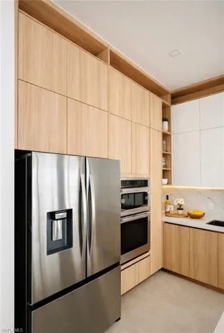 Kitchen with modern cabinets, stainless steel appliances, open shelves, two tone cabinetry, and decorative backsplash