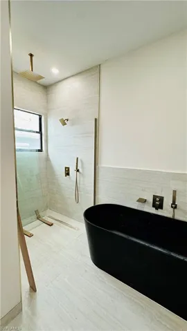 Full bath with a soaking tub and a walk in shower