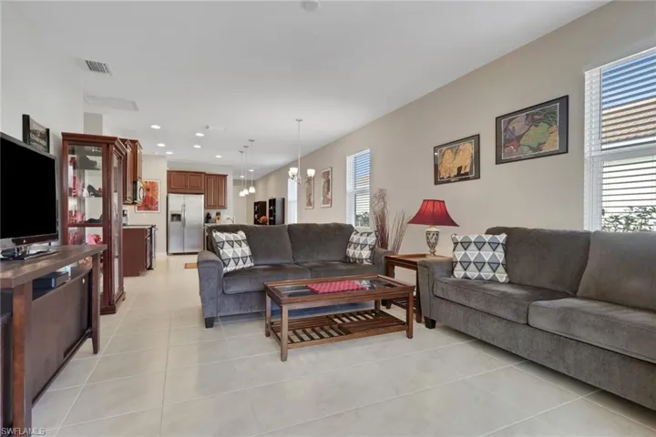 Living area with a chandelier, light tile patterned flooring, and recessed lighting