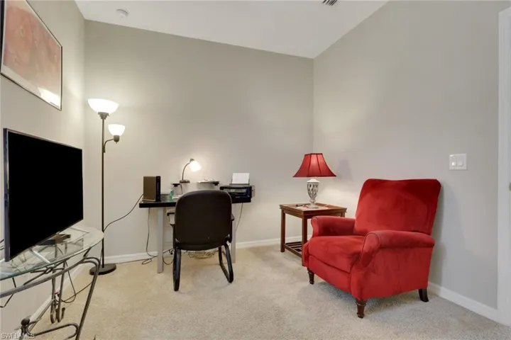 Office space with light colored carpet and baseboards