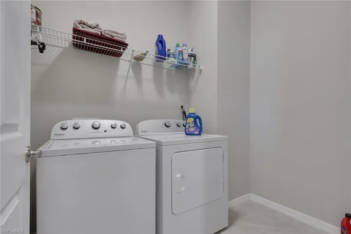 Laundry area with baseboards and washer and clothes dryer