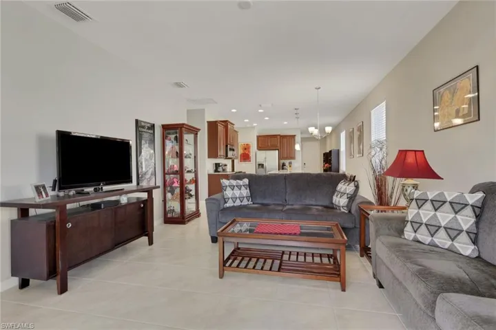 Living room featuring a chandelier, light tile patterned flooring, and recessed lighting