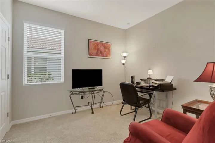 Home office with light colored carpet and baseboards