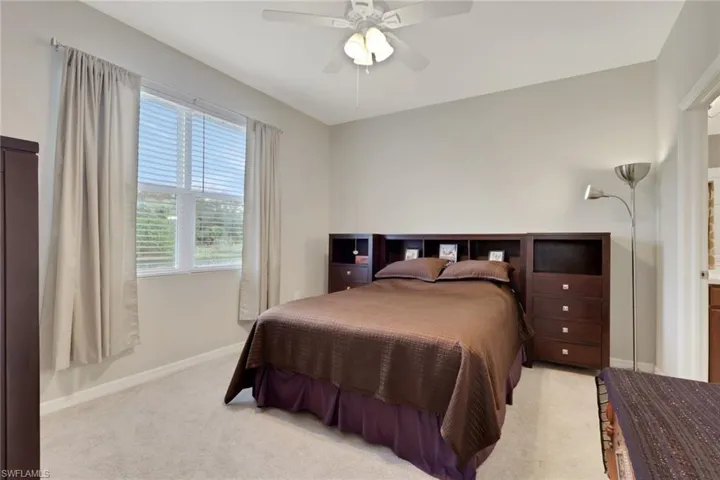 Bedroom with ceiling fan and light carpet