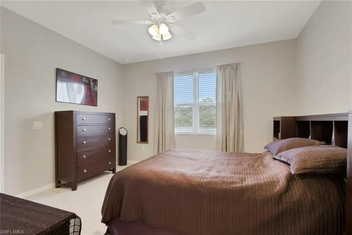 Bedroom featuring light colored carpet and a ceiling fan
