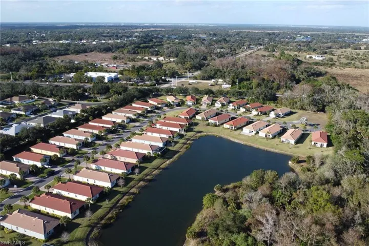 Aerial view of property's location with a nearby body of water and nearby suburban area