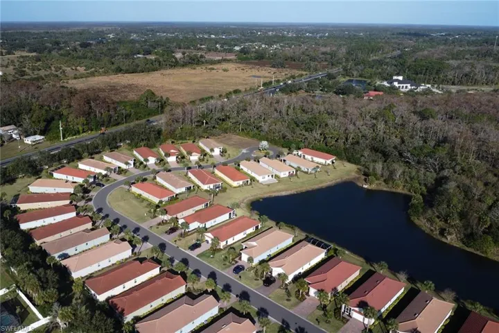 Aerial view of property and surrounding area featuring a large body of water and nearby suburban area