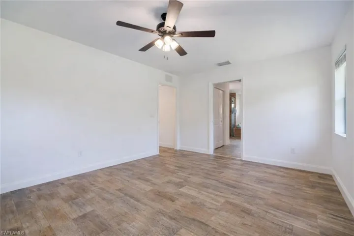 Unfurnished bedroom with ceiling fan and light wood finished floors