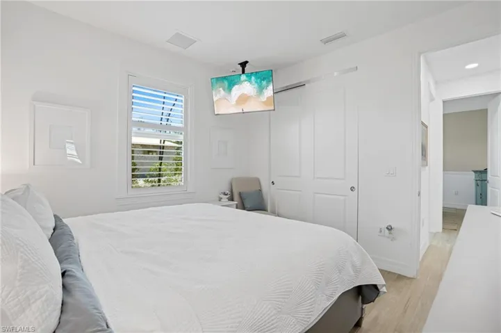 Bedroom featuring light wood-type flooring, a closet, visible vents, and baseboards