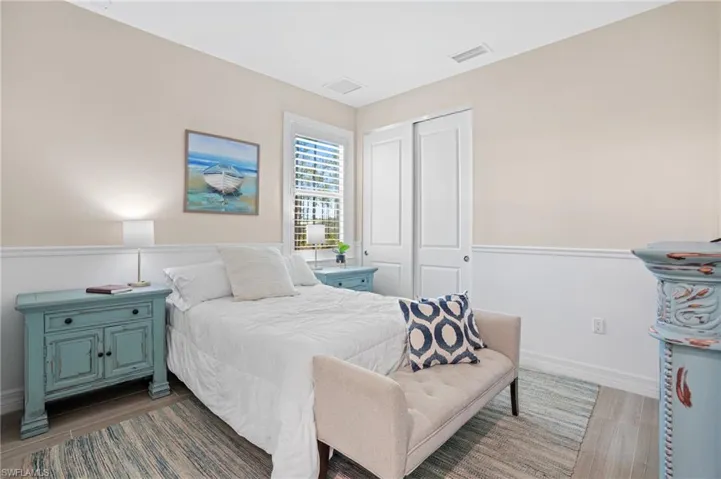Bedroom featuring a closet, wood finished floors, visible vents, and baseboards