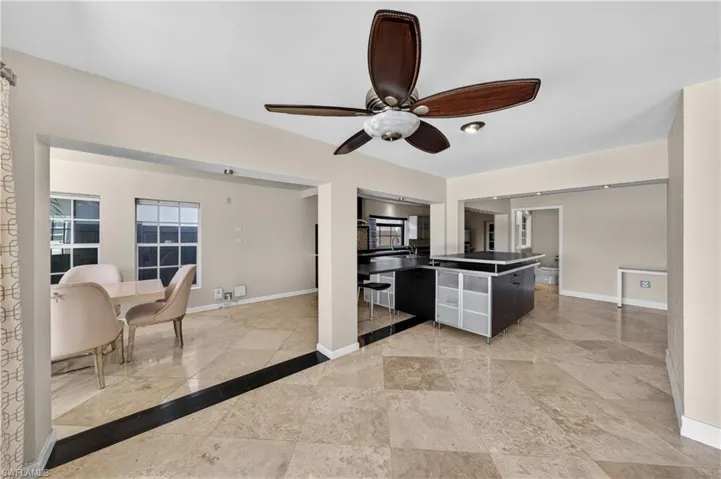 Expansive living area with tile flooring, a ceiling fan, and recessed lighting