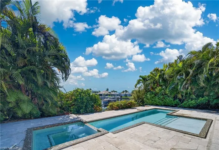 The property features an outdoor swimming pool with an integrated spa, surrounded by a paved patio