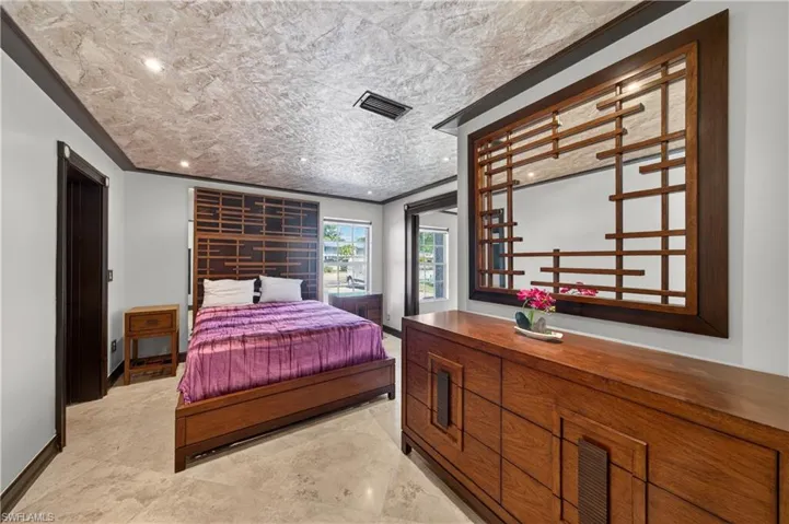 This room features a decorative wood-framed mirror, a matching wooden dresser, and a bed with a wooden frame and headboard