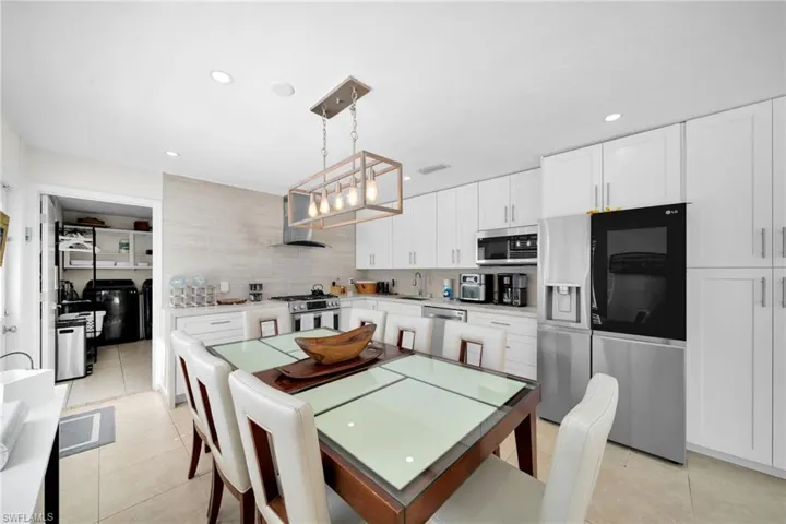 Dining area featuring light tile patterned floors, washer and dryer, and recessed lighting