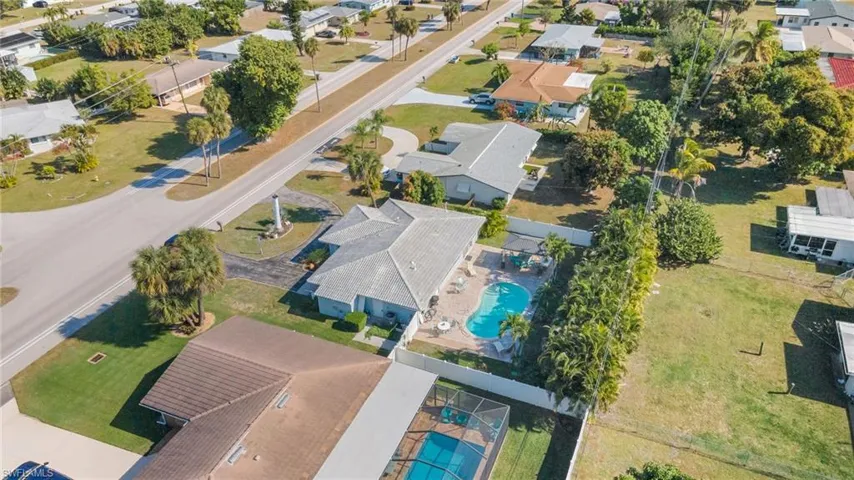 View of property location with a pool and nearby suburban area
