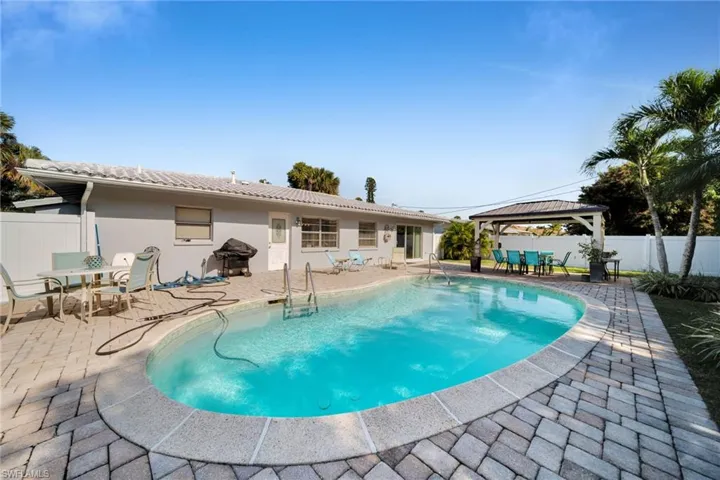 View of swimming pool with a patio area, a fenced backyard, a gazebo, and outdoor dining space