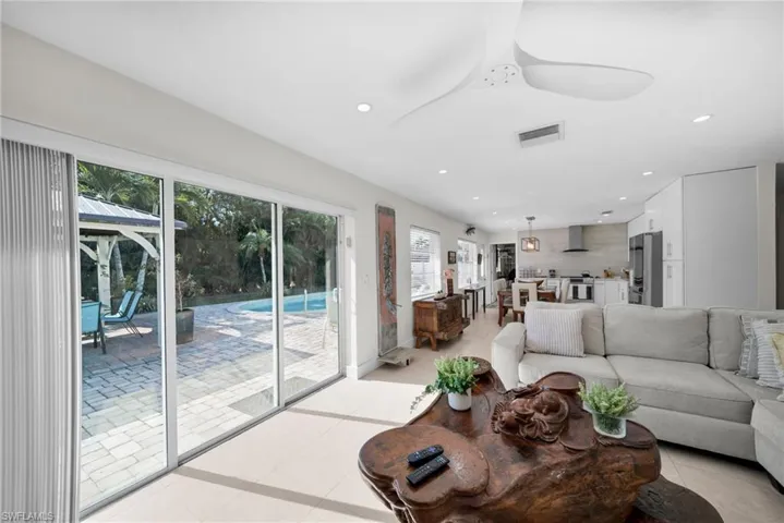Living room featuring recessed lighting, light tile patterned flooring, and a ceiling fan
