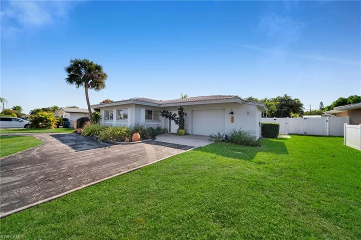 Single story home with a garage, driveway, stucco siding, and a gate