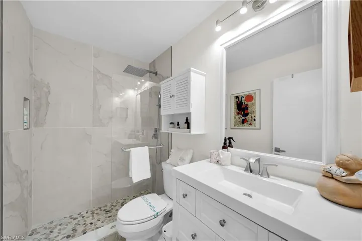 Full bathroom featuring vanity and a marble finish shower