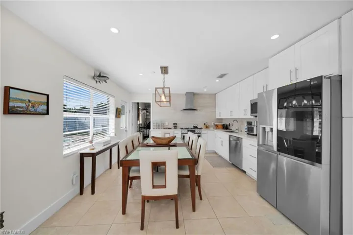 Dining space with light tile patterned floors and recessed lighting