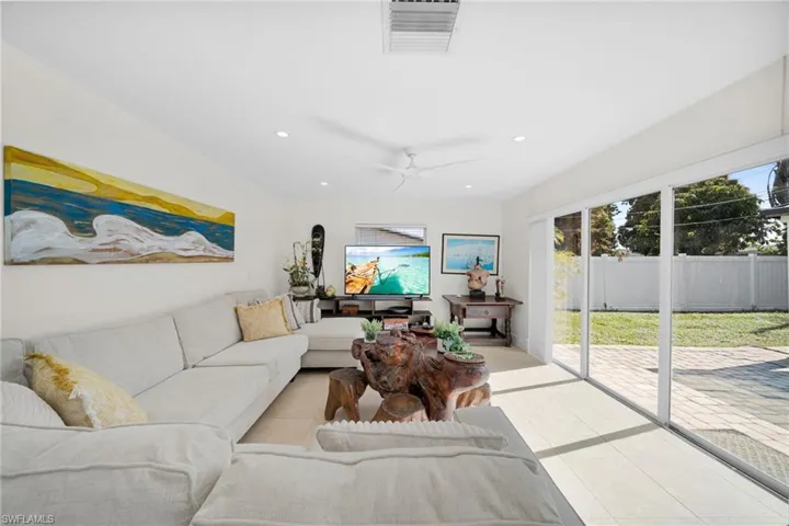 Living area with tile patterned flooring, a ceiling fan, and recessed lighting